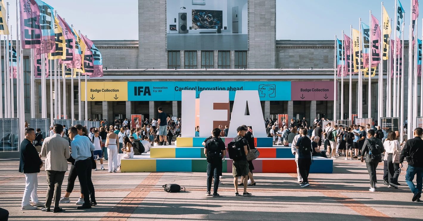 Visitors gathering outside Messe Berlin ahead of the IFA entrance, beneath IFA flags and a large IFA letter installation